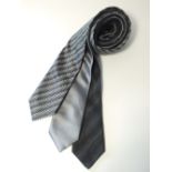 Three ties, one black woven pattern, one black, white and grey chequerboard pattern, one silver,