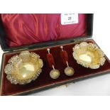 A case pair of silver salts with salt spoons.