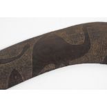 An Australian carved hard wood boomerang the decoration to one side only depicting two emus and a