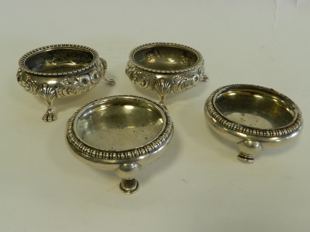 A pair of Victorian silver salts with embossed floral decoration together with a further pair of