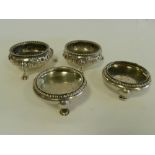 A pair of Victorian silver salts with embossed floral decoration together with a further pair of