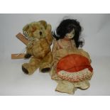 A puppet in the form of a teddy bear and a Bisque headed doll with open eyes,