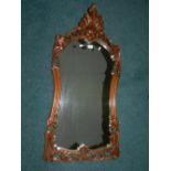 A Rococo style walnut framed wall mirror (replacement mirror plate)