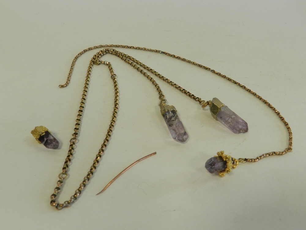 A rough amethyst crystal pendant with yellow metal chain together with further mounted rough