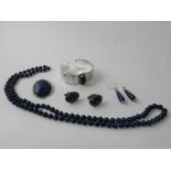 A lapis lazuli set bangle together with a pair of lapis lazuli ear pendants,