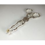 A pair of white metal sugar nips, with shell moulded pincers, weight 1.