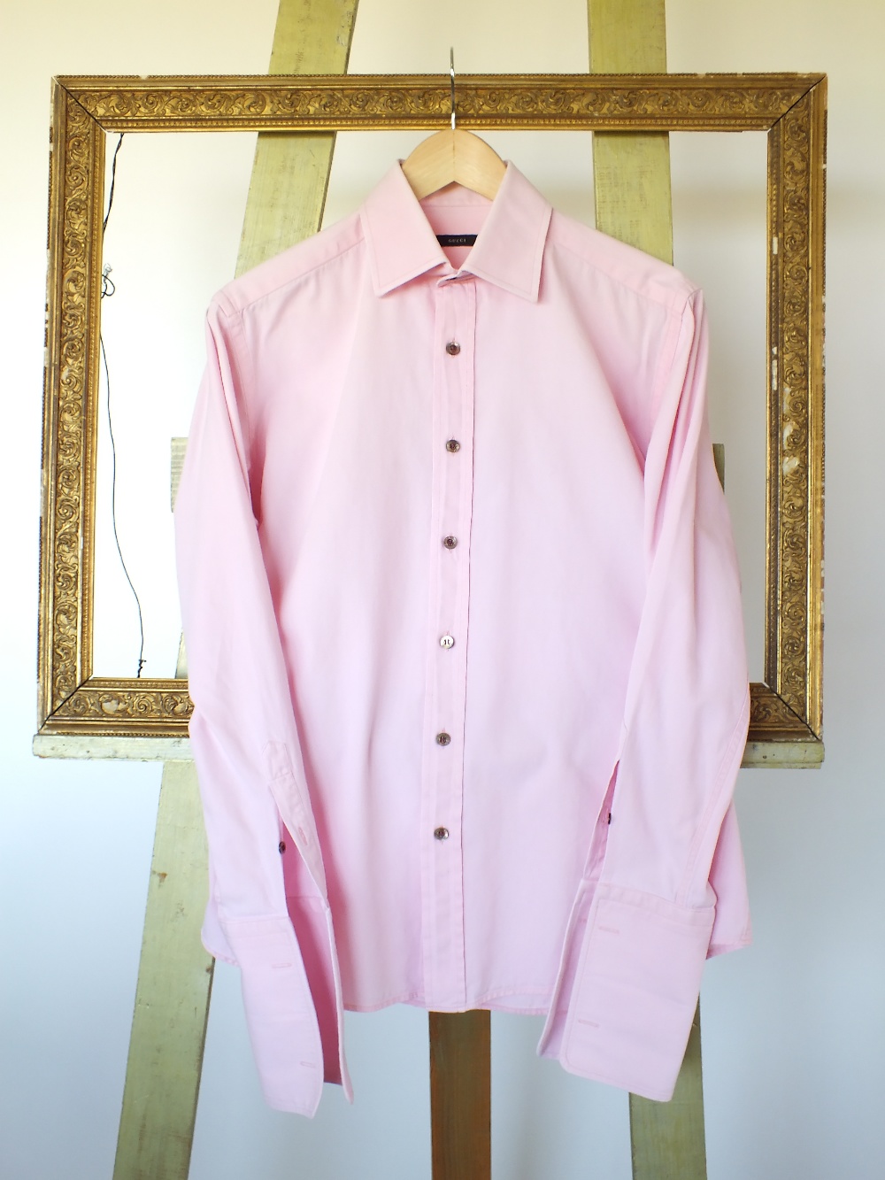 A Gucci shirt, pink, with black buttons,