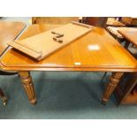 A Victorian mahogany wind-out dining table on four ball and reeded tapering legs with extra leaf,