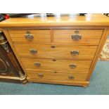 An Edwardian satin birch chest of two short over three long drawers on compressed bun feet,