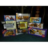 A box containing nine boxed earth moving models in various scales and manufacturers to include CAT,