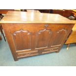 A George III design oak mule chest with split hinged top above three ogee arched fielded panels and