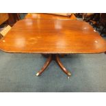 A mahogany tilt-top breakfast table on baluster column and four down-curved legs,