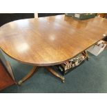 A 20th century reproduction twin pedestal dining table in the Regency style with brass lion claw