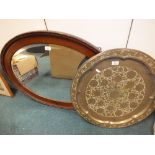 An Edwardian oval mahogany framed mirror together with a near Eastern brass dish