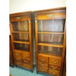 A pair of Empire style mahogany free standing bookshelf units each with six drawers below,