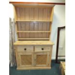 A pine floor standing high kitchen dresser with three shelf delft rack over two short drawers and