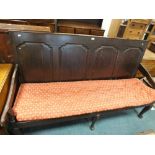 An early 19th century oak coaching settle with four ogee arched panels to the back and on cabriole