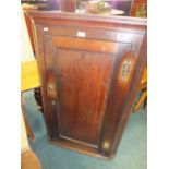 An early 19th century oak straight front corner cupboard with canted angles, 73cm wide, 33cm deep,