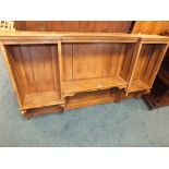 A faded mahogany wall shelf of inverted breakfront form,