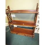 A modern mahogany wall shelf in Chippendale style with three blind fret drawers below,