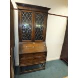 A 1920s Jacobean style bureau bookcase with two leaded glass doors above slope front and two