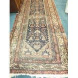 A Persian indigo ground wool runner with red and white multiple guard stripes, heavily worn,