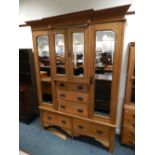 An Art Nouveau deal triple wardrobe with double cabinet mirror doors above three short drawers