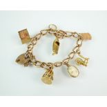 A yellow metal curb link bracelet, stamped '9ct', with attached 9ct gold and yellow metal charms,