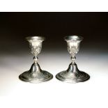 A pair of early 20th century Persian silver candlesticks, stamped '84', each with chased decoration,