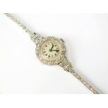 A ladies platinum and diamond set wristwatch, the circular silvered dial with black Arabic numerals,