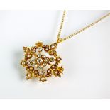 A diamond and pearl openwork pendant/brooch, suspended from yellow metal chain,