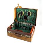 A comprehensive cased silver and tortoiseshell mounted travelling dressing table set,