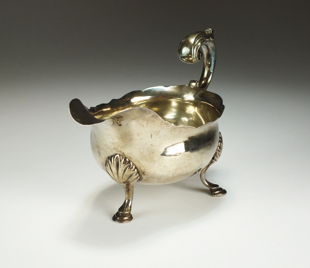 A George III silver sauce boat, William Skeen, London 1767, of typical form with cusped rim,