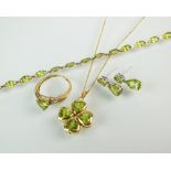 An 18ct gold four stone peridot pendant, suspended from 9ct gold chain,