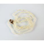A single strand seed pearl necklace, with yellow metal rose cut diamond set clasp,
