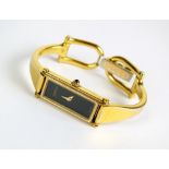 A Lady's Gucci gold plated wristwatch, with black rectangular dial, quartz movement,