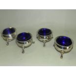 A set of four silver cauldron salts with blue glass liners