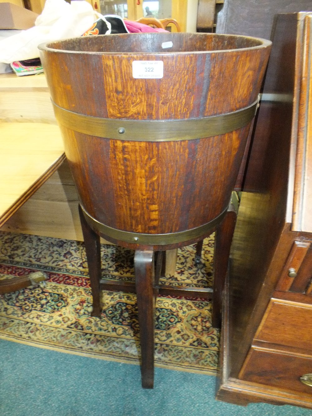 An oak jardiniere stand of coopered barrel form with retailers label for R A Lister and Co.