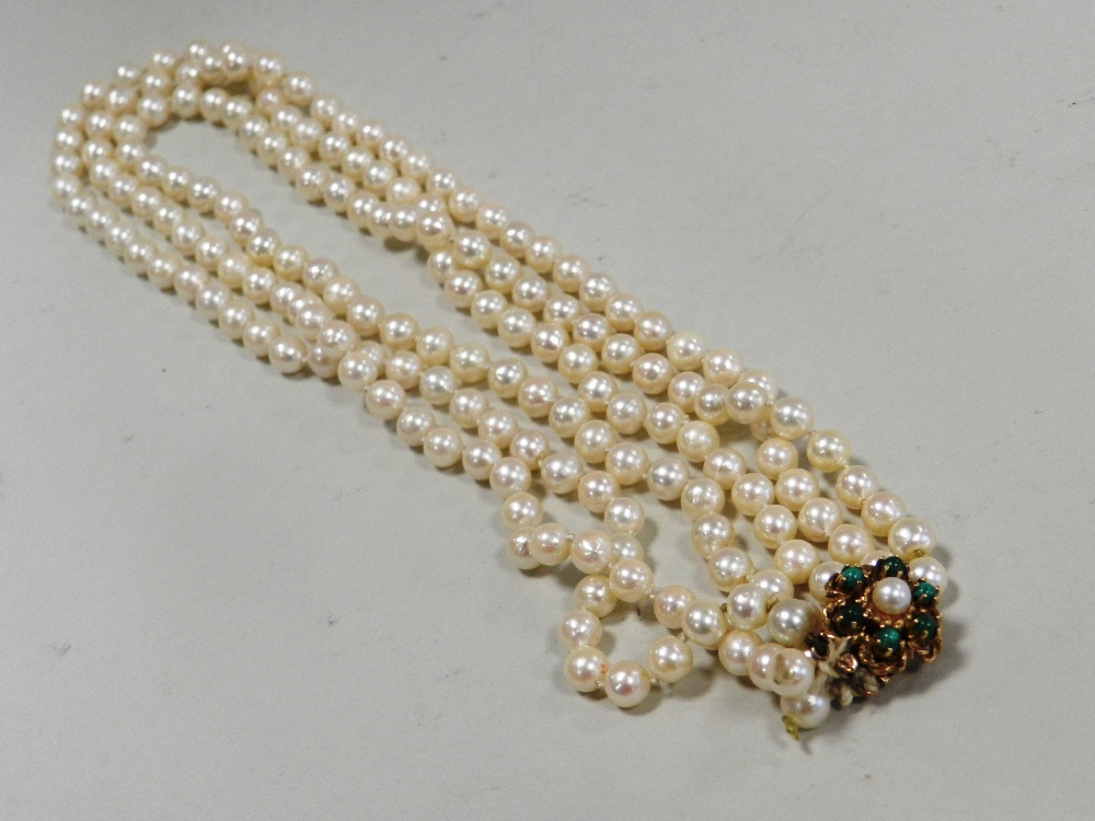 A three strand cultured pearl necklace with yellow metal clasp stamped 9ct