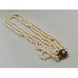 A three strand cultured pearl necklace with yellow metal clasp stamped 9ct