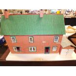 A doll's house, two storey with garage and fitted for electricity on white painted plinth,