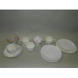 An English porcelain white undecorated part tea set with moulded Rococo panel together with an