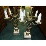 A pair of reproduction Rococo style cast metal four light candelabra each with figural cherub