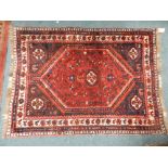 A small Persian red and indigo blue ground rug with lozenge medallion within multiple guard stripes,