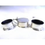 A silver mustard together with a pair of silver salts with blue glass liner and a silver mustard