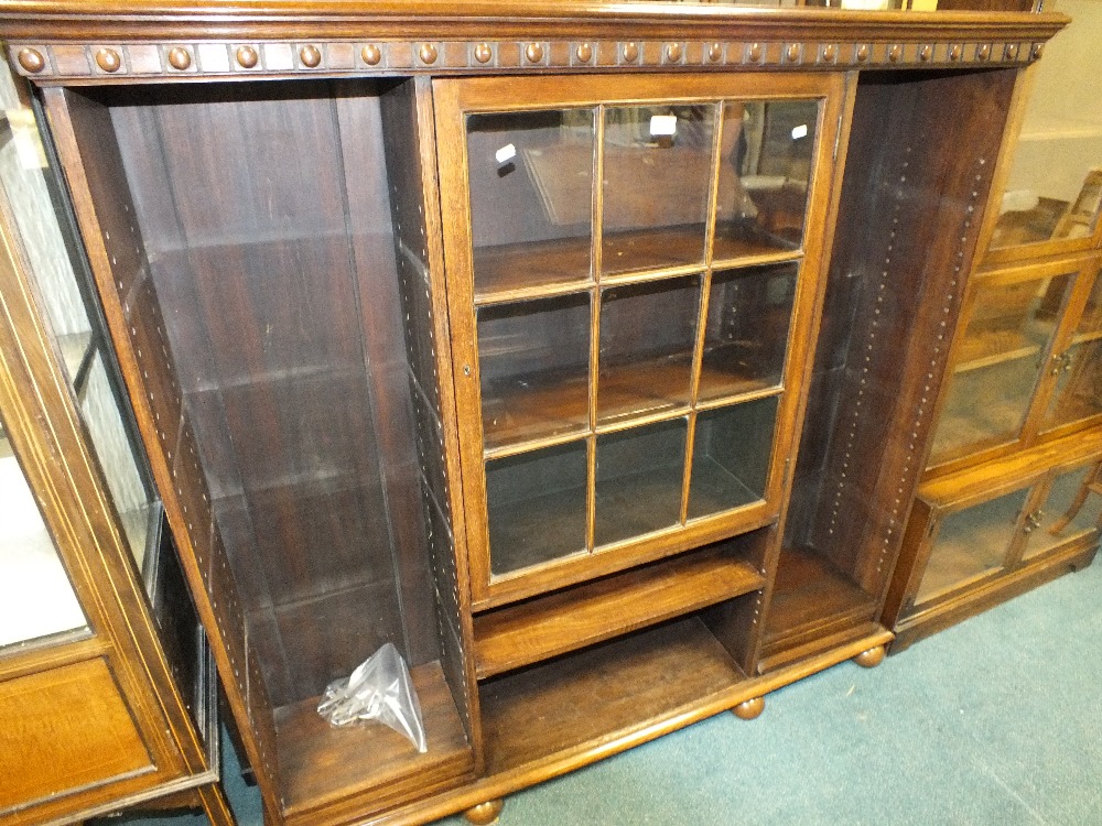 A large oak free standing bookcase with nine pane ribbed glazed central door above adjustable