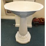 A large white glazed moulded stoneware garden fountain