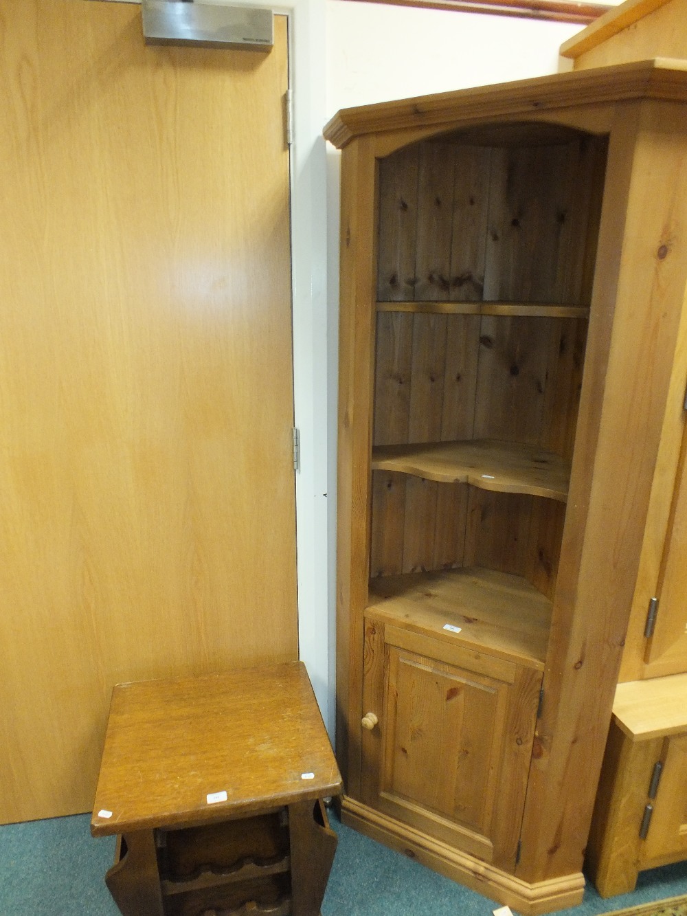 A modern pine full height corner unit with two shaped open shelves above a fielded panel cupboard