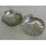 A pair of silver butter dishes in the form of shells,