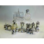 Six division silver toast rack together with two small silver cream jugs, a silver egg cup,